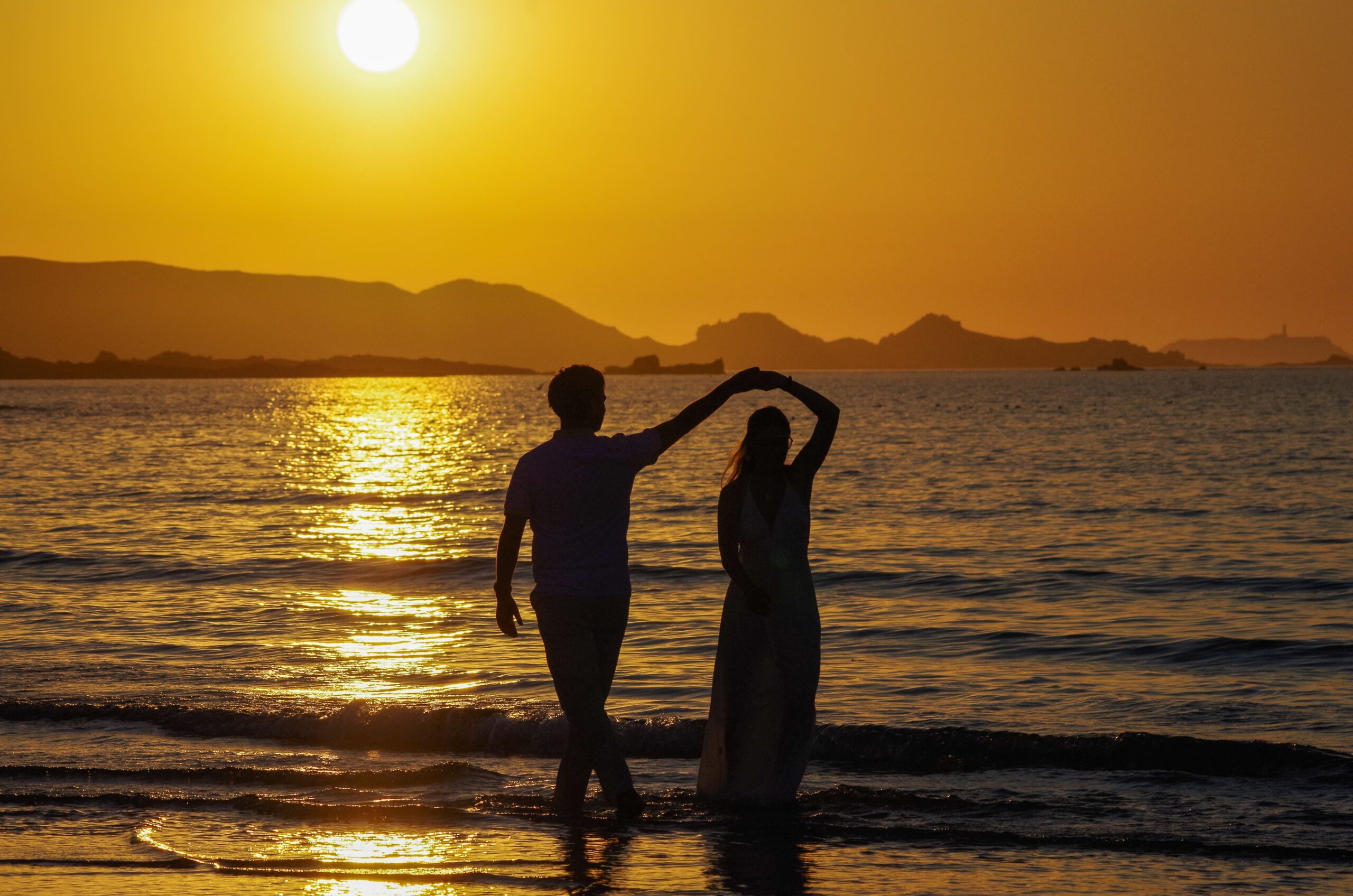 Deux amoureux qui danse au bord de l'eau avec le coucher de soleil en arrière plan séance photo "entre amoureux"