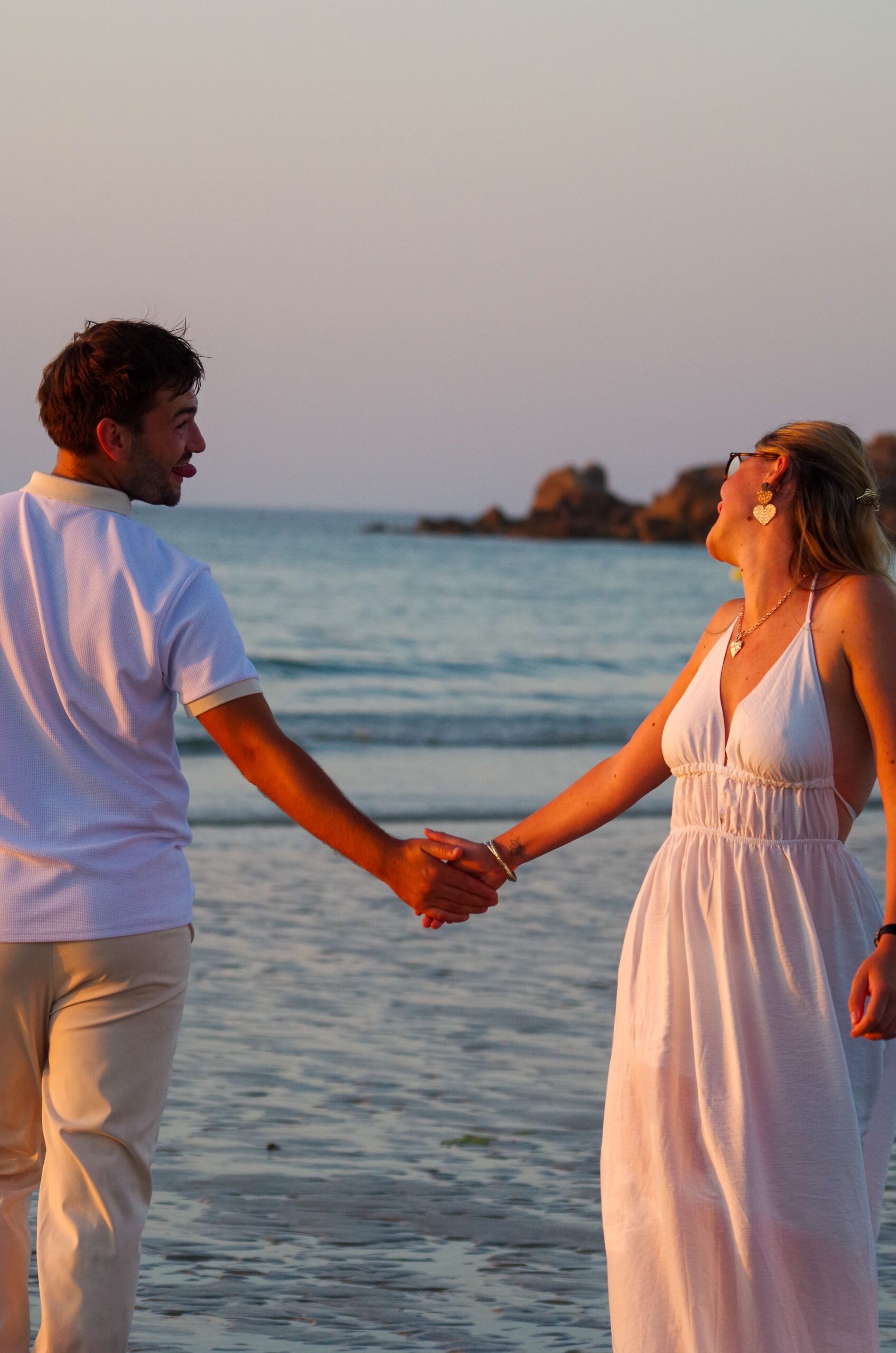 Couple qui tienne la main sur la plage en dansant